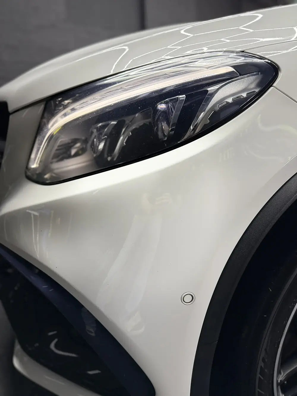 Close-up of a modern car headlight showcasing the sleek design and polished finish.