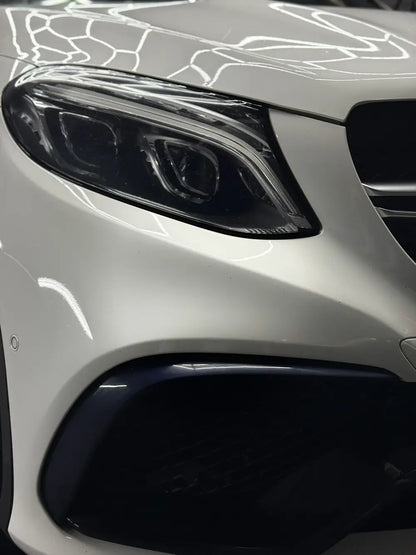 Nahaufnahme eines eleganten weißen Autoscheinwerfers, der für klare Sicht sorgt.