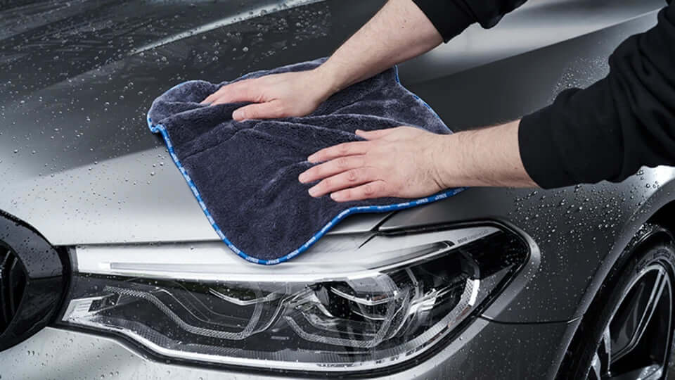 Mikrofasertuch nimmt Wasser von Scheinwerfer und Motorhaube auf – Glas und Lack schonend, schlierenfrei trocknen