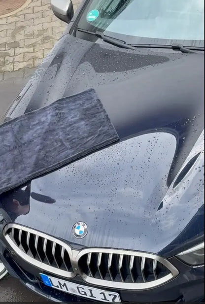 Viscura Trockentuch MAX on a sleek BMW hood, showcasing its water-absorbing capabilities for car drying.